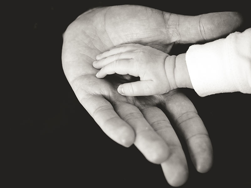 babafotó kéz fekete fehérben